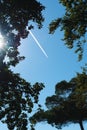 A white trace from the plane against the background of a clear blue sky. Vertical Royalty Free Stock Photo