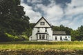 White traditional Irish house among trees, fields. Royalty Free Stock Photo