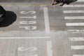 STOP sign traffic on street caution black car driver to stop at crossing line, two people crossing crosswalk. Royalty Free Stock Photo