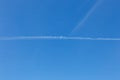 White trail from the plane against the blue sky. Royalty Free Stock Photo