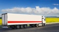 White trailer on the highway, against the background of a green field Royalty Free Stock Photo