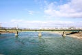 White train is crossing a big river by the bridge under bright blue sky Royalty Free Stock Photo