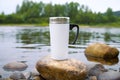 White travel mug mockup with stony river bottom