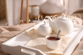 White tray with ceramic tea set on bed Royalty Free Stock Photo