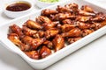 white tray filled with shiny, glazed honey bbq chicken wings