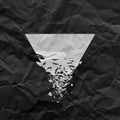 White triangle with debris on black background with creased paper texture.