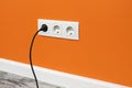 White triple outlet on orange wall Royalty Free Stock Photo