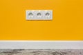 White triple outlet on yellow wall