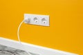 White triple outlet on yellow wall Royalty Free Stock Photo