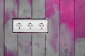 White triple power socket electric outlet plug voltage on wooden painted decorative color boards modern interior