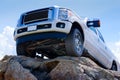 White truck on cliff edge showing undercarriage Royalty Free Stock Photo