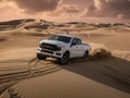 White truck driving down a sand dune Royalty Free Stock Photo