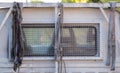 White truck. Rear window with grill and ropes.