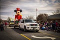 A white truck transporting Micky Mouse in a Christmas parade