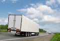 White trucks on country highway under blue sky