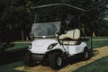 White Little Cart on Golf Field in Sunny Day. Royalty Free Stock Photo