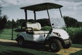 White Little Cart on Golf Field in Sunny Day. Royalty Free Stock Photo