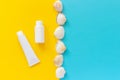 White tube, bottle of sunscreen and line seashells on yellow and blue paper background. Mock up Template for lettering, text or