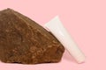 White tube with cream next to brown stone. Stone pattern with texture. Royalty Free Stock Photo