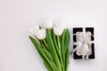 White tulip flowers and black gift box on light background flat lay. Place for text 8 March Happy Womens Mothers Day Royalty Free Stock Photo