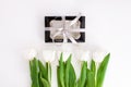 White tulip flowers and black gift box on light background flat lay. Place for text 8 March Happy Womens Mothers Day Royalty Free Stock Photo