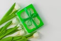 White tulip flowers and green gift box on light background flat lay. Bouquet greeting card. Website banner top view Royalty Free Stock Photo