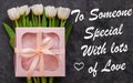 White tulip flowers and pink gift box on dark background flat lay.To Someone Special With Lots of Love card sign text Royalty Free Stock Photo
