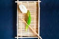 White tulip on a wooden tray for sushi on a blue background of concrete,space for textn