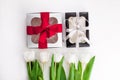 Spring website header template. White tulip black gift boxes with silver ribbon on light background flat lay. Copy space Royalty Free Stock Photo