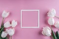 White tulips flowers and sheet of paper over light pink background. Saint Valentines Day frame or background.