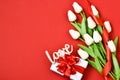 White tulips, gift box with wooden letters LOVE on a red background.