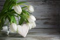 White tulips and a heart shape of wood against a vintage wooden Royalty Free Stock Photo