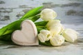 white tulips and a heart of wood on a vintage gray wooden background, love concept Royalty Free Stock Photo