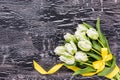 White tulips with yellow ribbon on black background. Copy space Royalty Free Stock Photo