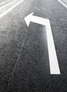White turn left arrow on the road Royalty Free Stock Photo