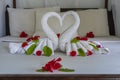 White two towel swans and red flowers on the bed in a hotel room Royalty Free Stock Photo