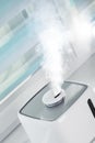 The white ultrasonic humidifier on a window moistens dry air Royalty Free Stock Photo