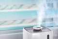 The white ultrasonic humidifier on a window moistens dry air Royalty Free Stock Photo