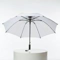 White umbrella with a black frame, open and displayed on a round white pedestal. The Royalty Free Stock Photo