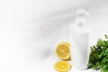 White unbranded bottle with lemon and green plants. Container with dispenser natural cosmetic products. Blank flacon for lotion, Royalty Free Stock Photo