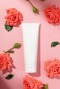 White unbranded flacon isolated on pink background. Body lotion or soft face cream. Mockup style. Flower for decorations, eco-