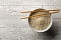 White uncooked, raw long grain rice in white bowl with chopsticks on rustic white wooden table with copy space top view flat lay Royalty Free Stock Photo