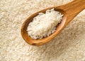 White uncooked, raw long grain rice full frame with wooden spoon top view flat lay from above