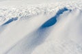 White uneven snow texture with embossed shadows. Abstract background with snowy surface in spring time