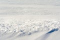 White uneven snow texture with embossed shadows. Abstract background with snowy surface in spring time