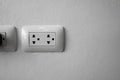 White universal electricity sockets plug on a white wall. Royalty Free Stock Photo