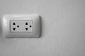 White universal electricity sockets plug on a white wall. Royalty Free Stock Photo