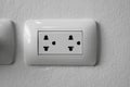 White universal electricity sockets plug on a white wall. Royalty Free Stock Photo