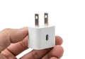 White universal travel adapter held in a hand against a plain background Royalty Free Stock Photo