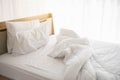 White unmade bed in the morning with sunshine with white curtain background in elegant home. Interior design and luxury furniture Royalty Free Stock Photo